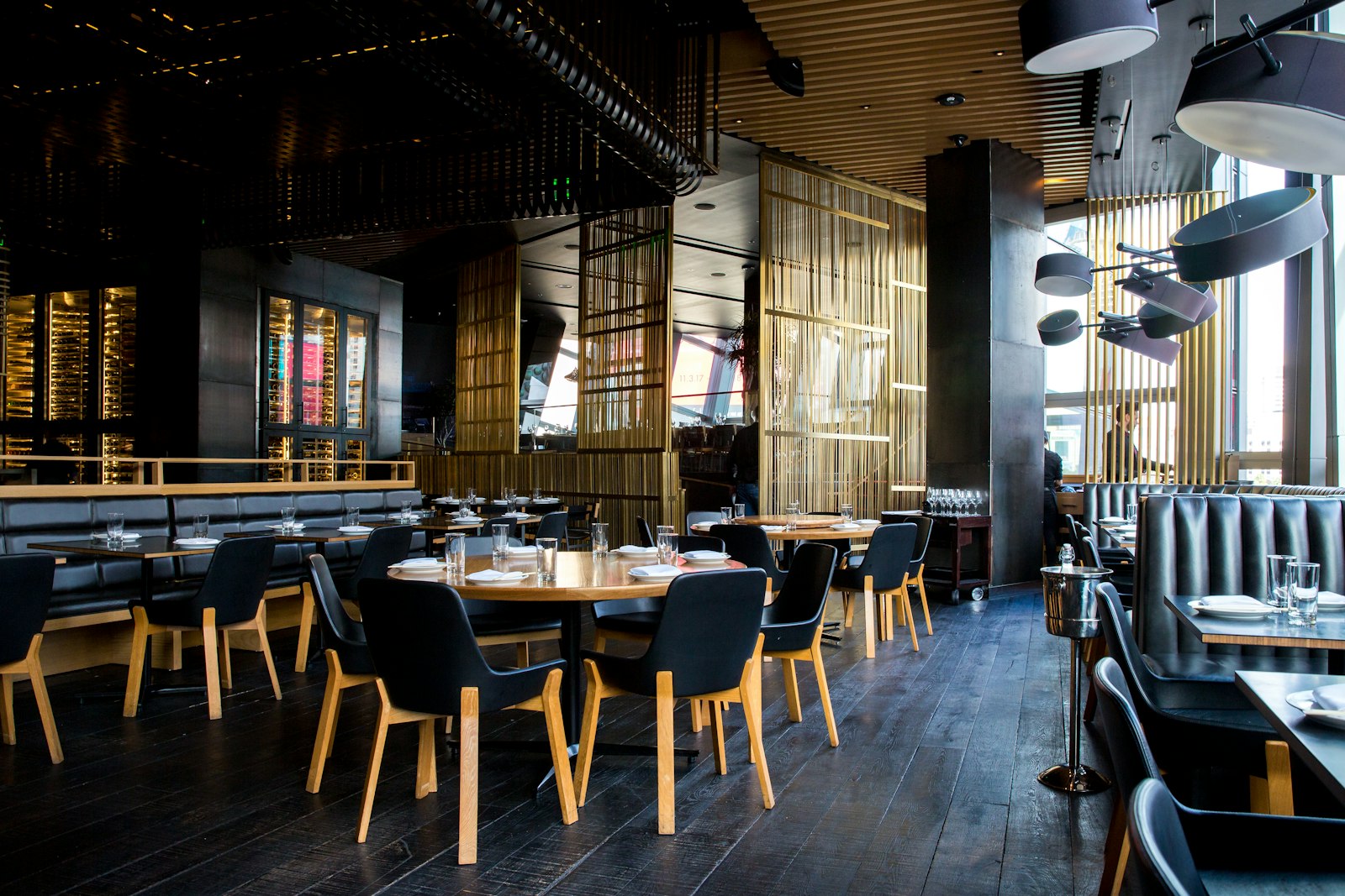 Warmly lit Maison Noir dining room with elegantly set tables